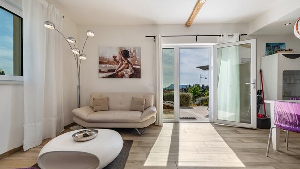 Un salon moderne avec un canapé, une table basse et un tableau accroché au mur.