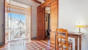 A room with a checkered floor, a wooden desk with a lamp, and a chair. - Holiday Home 'Ca Cedó' with Shared Terrace, Wi-Fi and Air Conditioning (La Serra d'Almos)