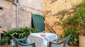 A small outdoor seating area with a table and chairs, surrounded by potted plants. - Holiday Home 'Ca Cedó' with Shared Terrace, Wi-Fi and Air Conditioning (La Serra d'Almos)