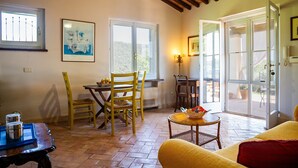 Una habitación con una mesa de comedor, sillas, un sofá y un ventanal con vistas.