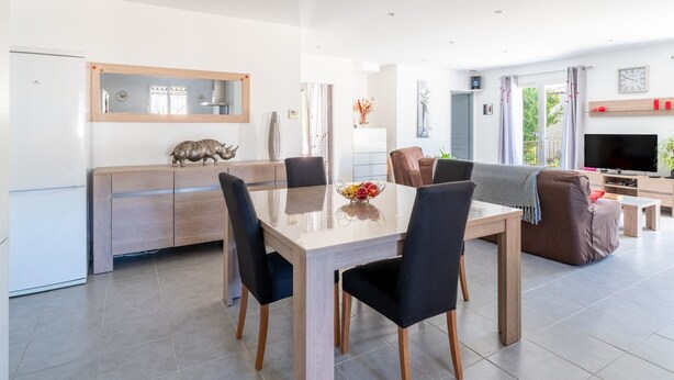 A modern living room with a dining area, a TV, and a large window. - Holiday Home “Villa De Maithe” with Private Terrace, Wi-Fi and Air Conditioning (Sernhac)