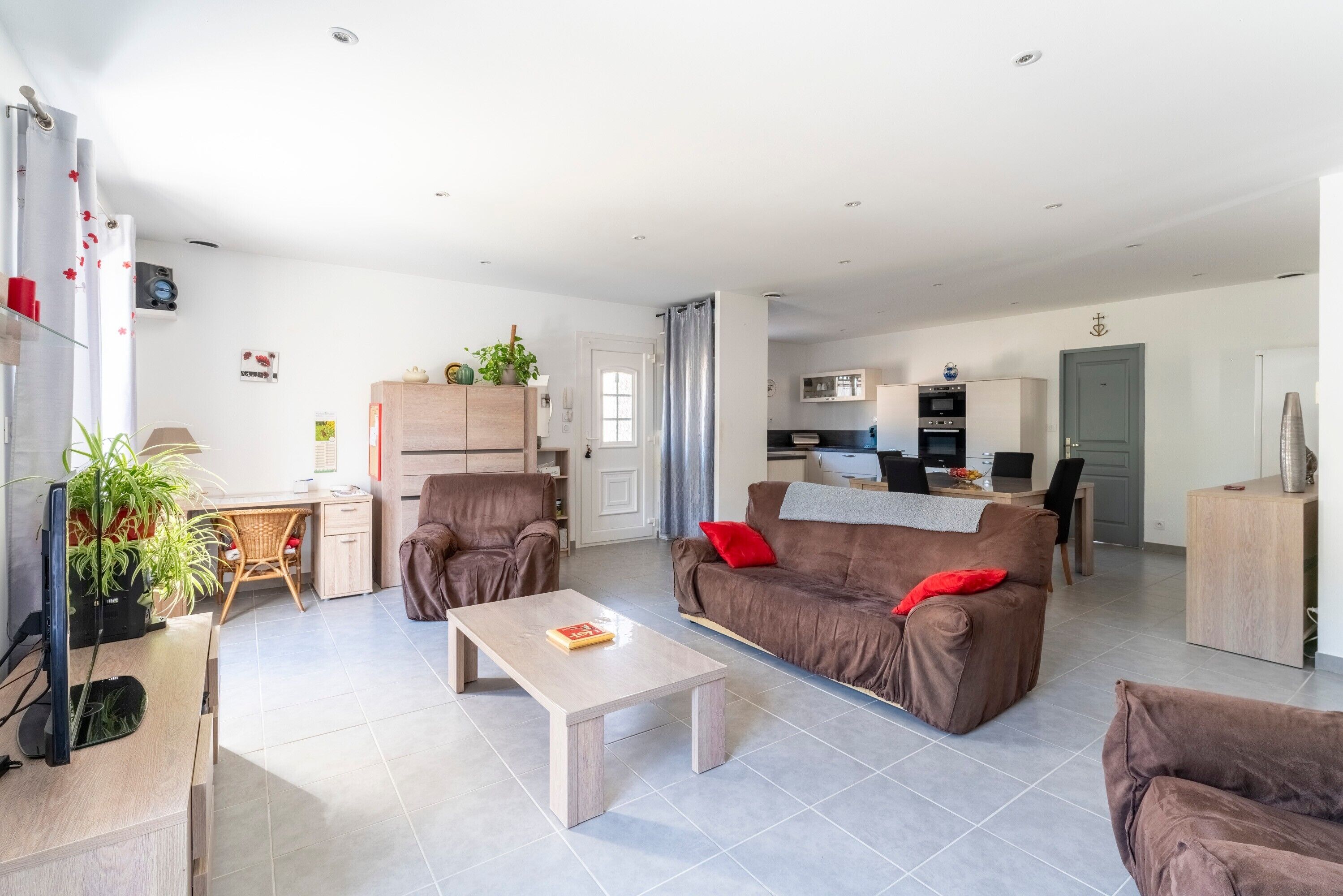 Un salon moderne comprenant un canapé, une table basse et un coin repas avec une table et des chaises.