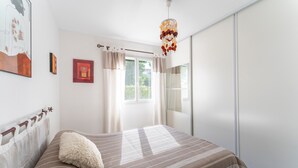 A bedroom with a bed, curtains, a window, and wall art. - Holiday Home “Villa De Maithe” with Private Terrace, Wi-Fi and Air Conditioning (Sernhac)