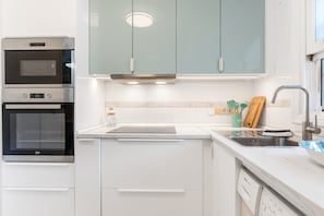 A modern kitchen with stainless steel appliances, a built-in oven, a dishwasher, and a sink with a faucet. - Apartment 'Casa Reina Abajo' with Shared Pool, Wi-Fi and Air Conditioning (Orihuela)