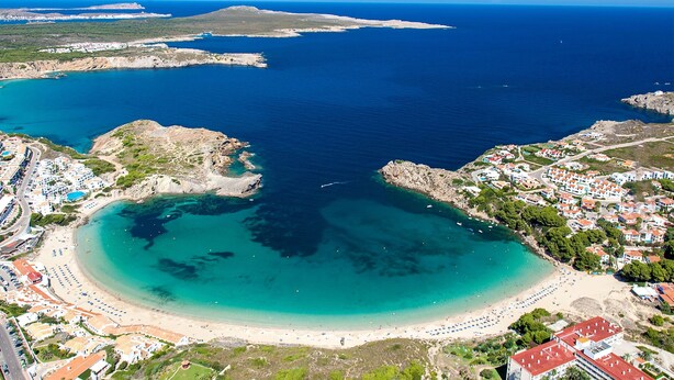 An aerial view of a coastal town with a beach, clear blue waters, and residential buildings. - Costa Arenal Apartment with Sea View, Premium Pool and Close to the Beach (Arenal d'en Castell)