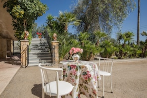 A patio with a table and chairs, a statue, and a gate. - Holiday Home 'Casa Venta Ruizo' with Mountain Views, Wi-Fi and Air Conditioning (Lorca Murcia)