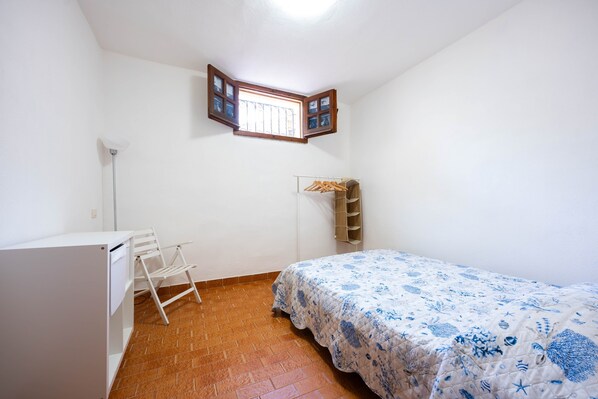 A bedroom with a bed, a desk, a chair, a wardrobe, a window, and a shelf. - Holiday Home 'Villa Costa Paradiso Del Sud' with Sea View, Terrace and Air Conditioning (Cala Sinzias)