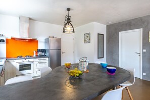 A modern kitchen with a central island, a built-in oven, and a coffee machine.