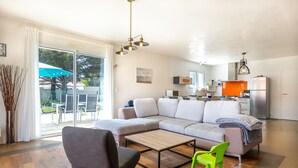 Ein modernes Wohnzimmer mit einem Ecksofa, einem Couchtisch und einem leuchtend grünen Sessel.