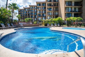 Un hôtel doté d’une piscine, de plusieurs balcons et de palmiers.