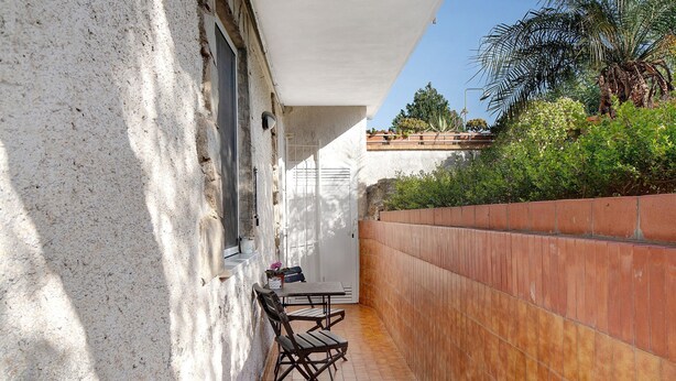 A narrow outdoor patio with a table and chairs, a white wall, and a tiled floor. - Apartment 'Casa Di Lo' with Private Terrace and Wi-Fi (Laigueglia)