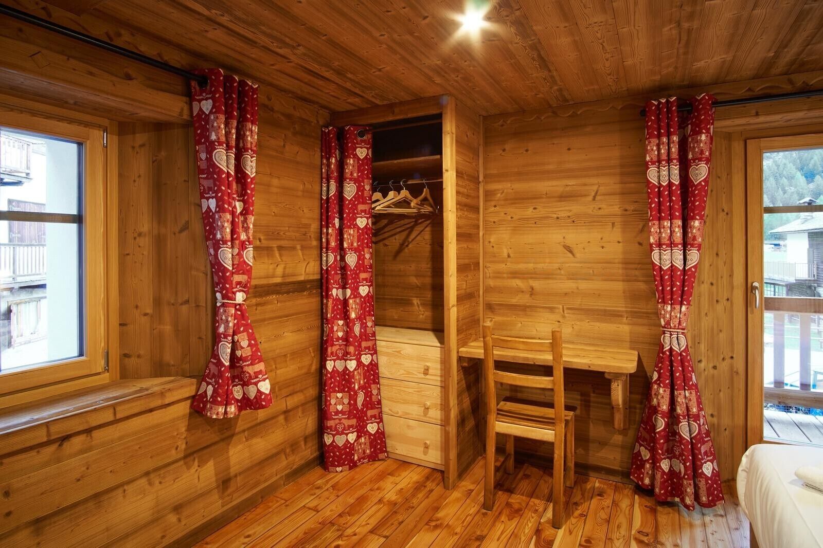 Ein Holzinterieur mit Schreibtisch, Stuhl und Kleiderschrank aus Holz.
