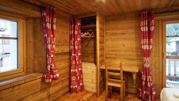 Ein Holzinterieur mit Schreibtisch, Stuhl und Kleiderschrank aus Holz.