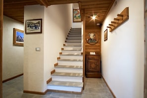 A staircase with wooden steps and a wooden door with a circular emblem.