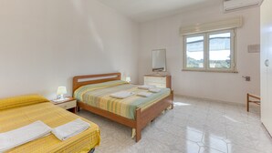 A bedroom with a bed, bedside tables, a dresser, a mirror, and a window with a view. - Apartment 'Villino Scapucci' with Sea View, Private Terrace and Air Conditioning (Santa Maria di Leuca)