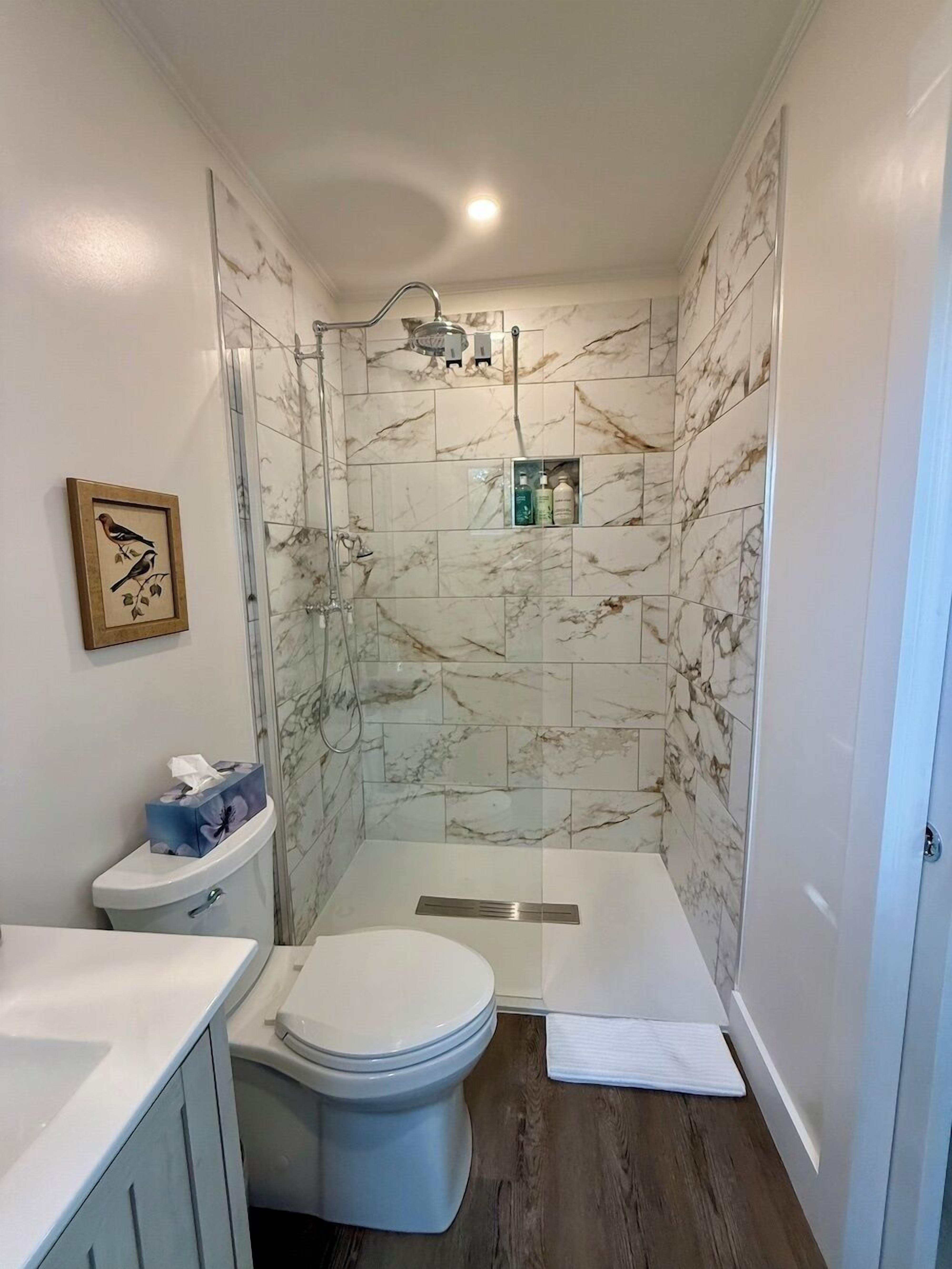 A bathroom with a shower, toilet, and sink.