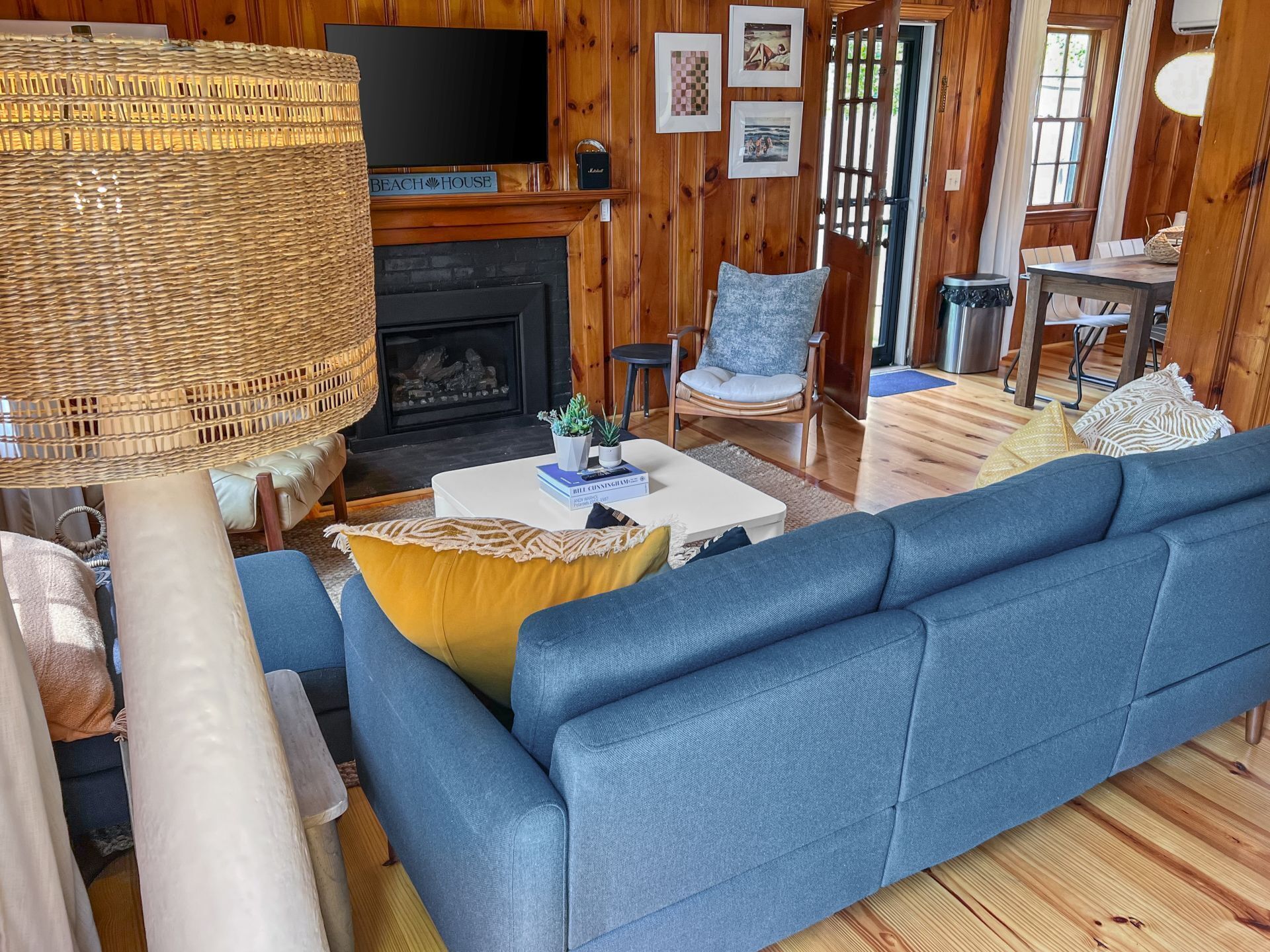 Ein gemütliches Wohnzimmer mit einem blauen Sofa, einem weißen Couchtisch und einem Kamin.