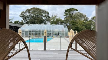 Relax in a serene poolside setting with a shaded view.