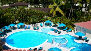 A pool area with multiple sections, lounge chairs, and umbrellas.