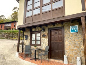 Un edificio de piedra con una puerta de madera marcada con el número “31” y un letrero que dice “La Macona”.