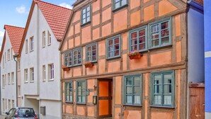 A traditional half-timbered building with a red-tiled roof, multiple windows, and flower boxes. - Ferienwohnung Waren (Müritz) (Waren (Müritz))