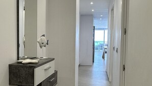 Une salle de bain moderne avec un grand miroir, un plan de toilette foncé et un lavabo blanc.