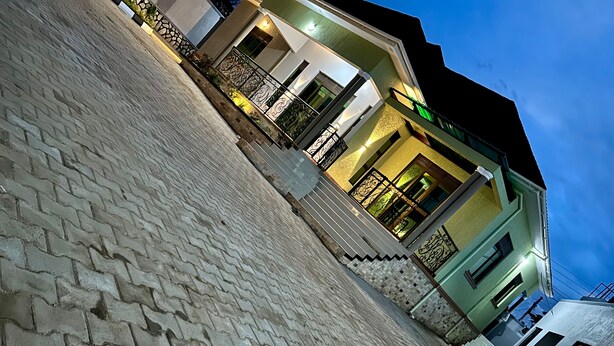 A paved courtyard with a staircase leading to a building with a balcony. - The residences -Wi-Fi 24/7 (Kampala)