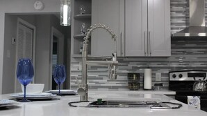 Una cocina moderna con pileta integrada, grifo de acero inoxidable y estufa.