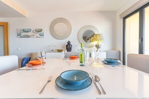 A dining area with a white table, blue and orange plates, and a bottle of Coca-Cola.