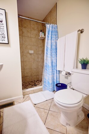 Een douche, handdoeken, zeep, shampoo