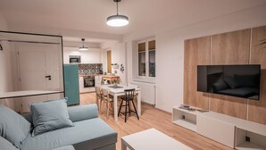 Un soggiorno moderno con un divano, un tavolo da pranzo e una TV a parete.