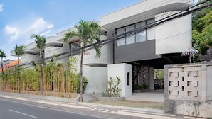 A modern building with a flat roof, multiple balconies, and a covered entrance. - Town House Camy Bali (Bali)
