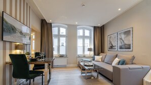 En moderne stue med spiseplads, en sofa, et sofabord og et fjernsyn.