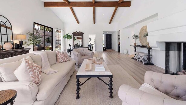 A spacious living room with a high ceiling, a fireplace, and a large window. - Desert Haven: Elegant 3BR/3BA in Indian Wells (Indian Wells)