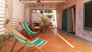 A covered patio with wooden furniture, including two chairs and a table. - AZZURRO E CASA VERDE - CASA VERDE (Campo nell'Elba)