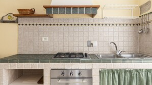 A kitchen with a gas stove, oven, and sink. - AZZURRO E CASA VERDE - CASA VERDE (Campo nell'Elba)