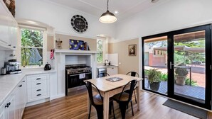 Une cuisine moderne avec un coin repas, une horloge et une vue sur l’extérieur.