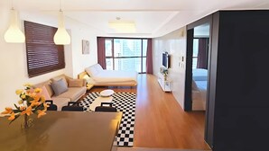 Una habitación de hotel moderna con sofá, mesa de comedor y suelo a cuadros.
