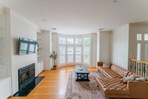 TV connectée, cheminée, table de tennis de table, livres