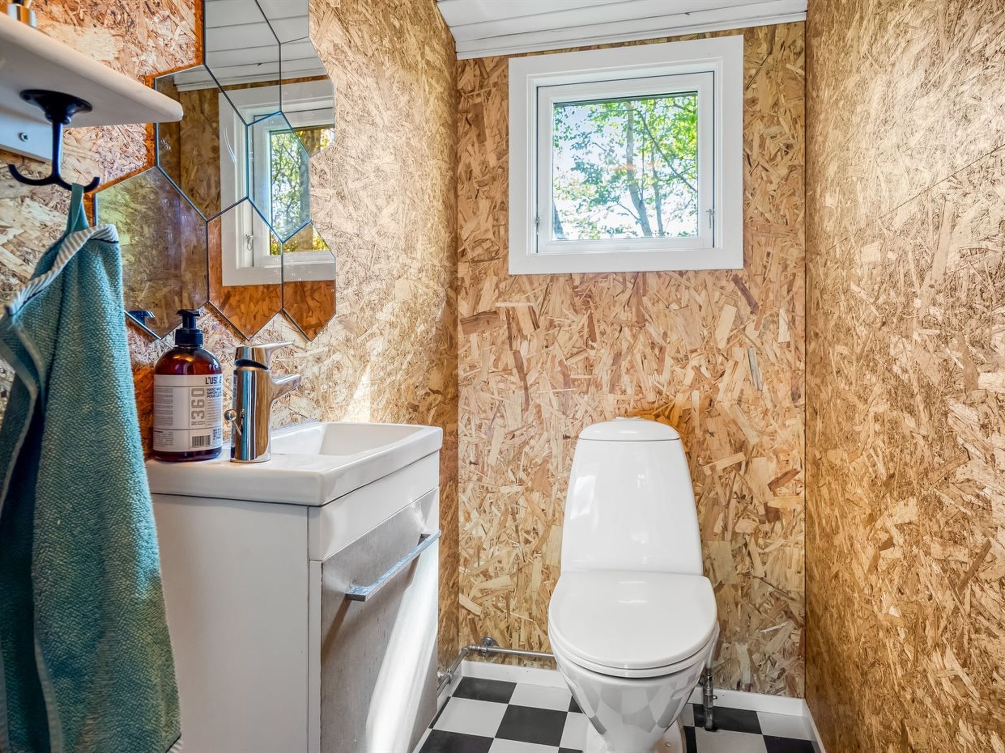 A bathroom with a toilet, a sink, and a window.