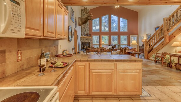 Une cuisine spacieuse avec des meubles en bois, un grand îlot central et une tête de cerf accrochée au mur.