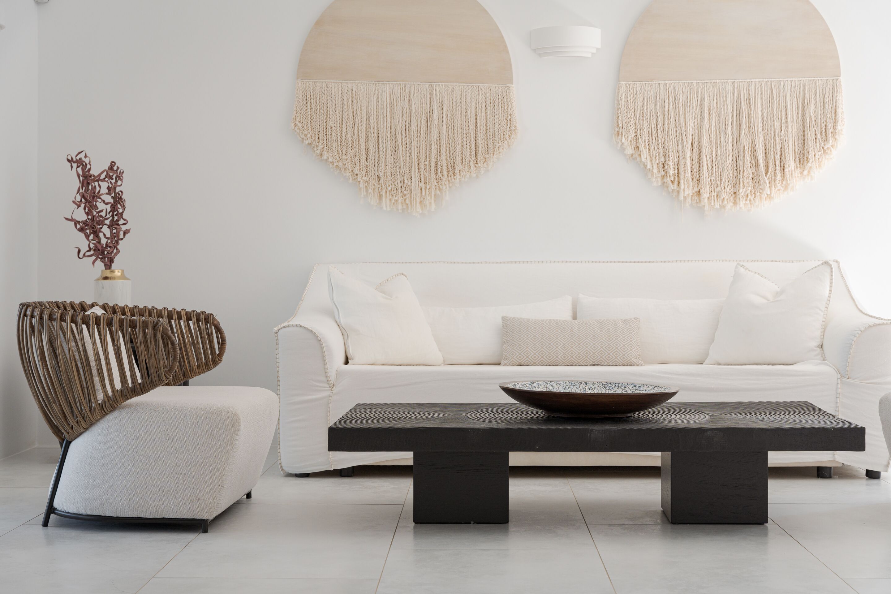 Uma sala de estar moderna com um sofá branco, uma mesa de centro de madeira escura e uma cadeira de fibra original.