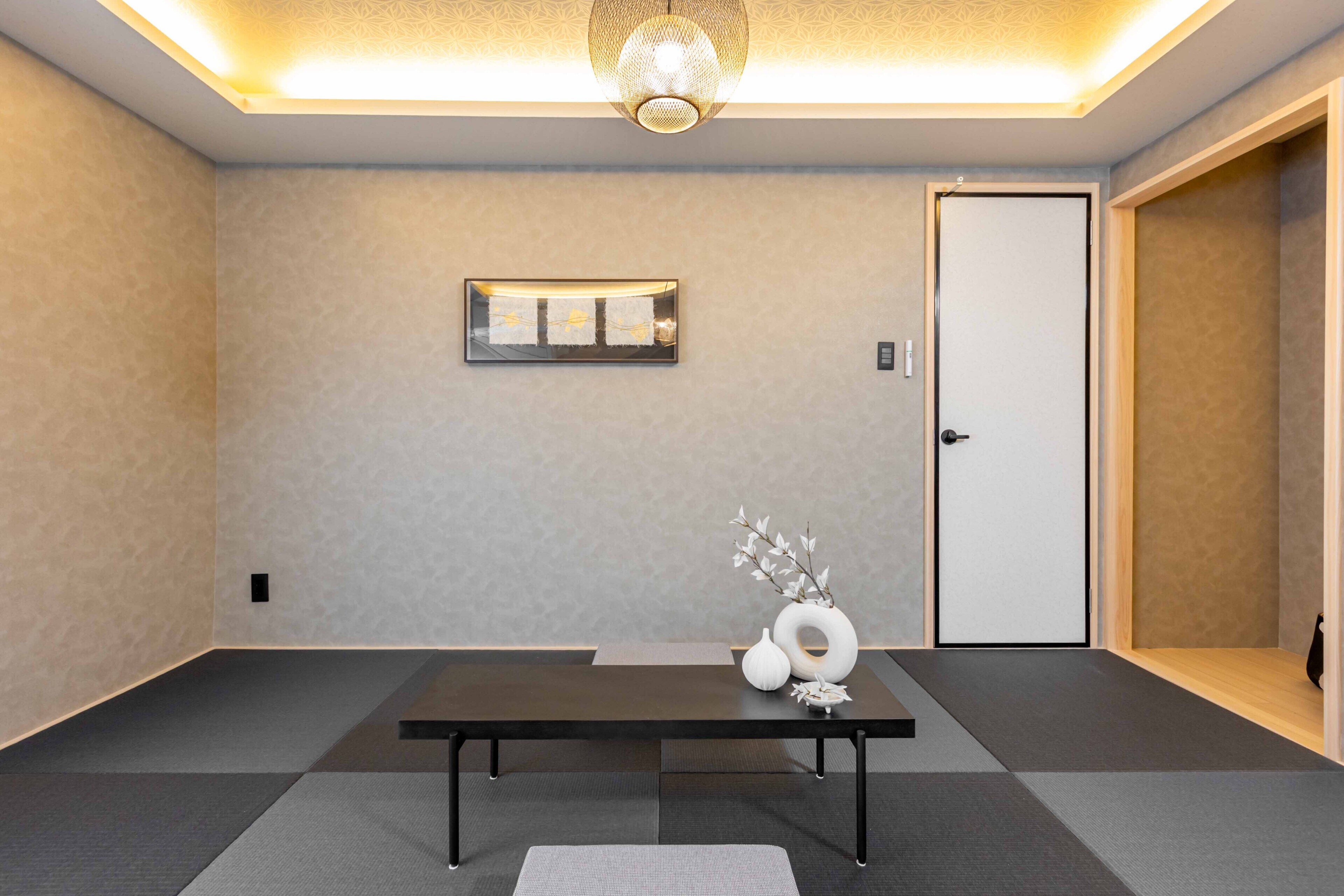 Ein modernes Hotelzimmer mit einem dunklen Holztisch, einer dekorativen Vase und einem gerahmten Kunstwerk an der Wand.