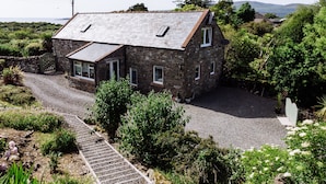 A stone house with a gravel driveway and a wooden staircase leading to the entrance. - Owl Cote -  a cottage that sleeps 5 guests  in 3 bedrooms (Gatehouse of Fleet)