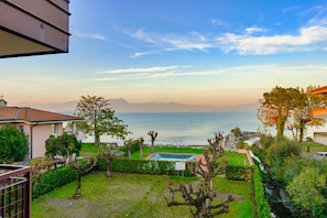 A residential area with a view of the sea, a swimming pool, and a garden.