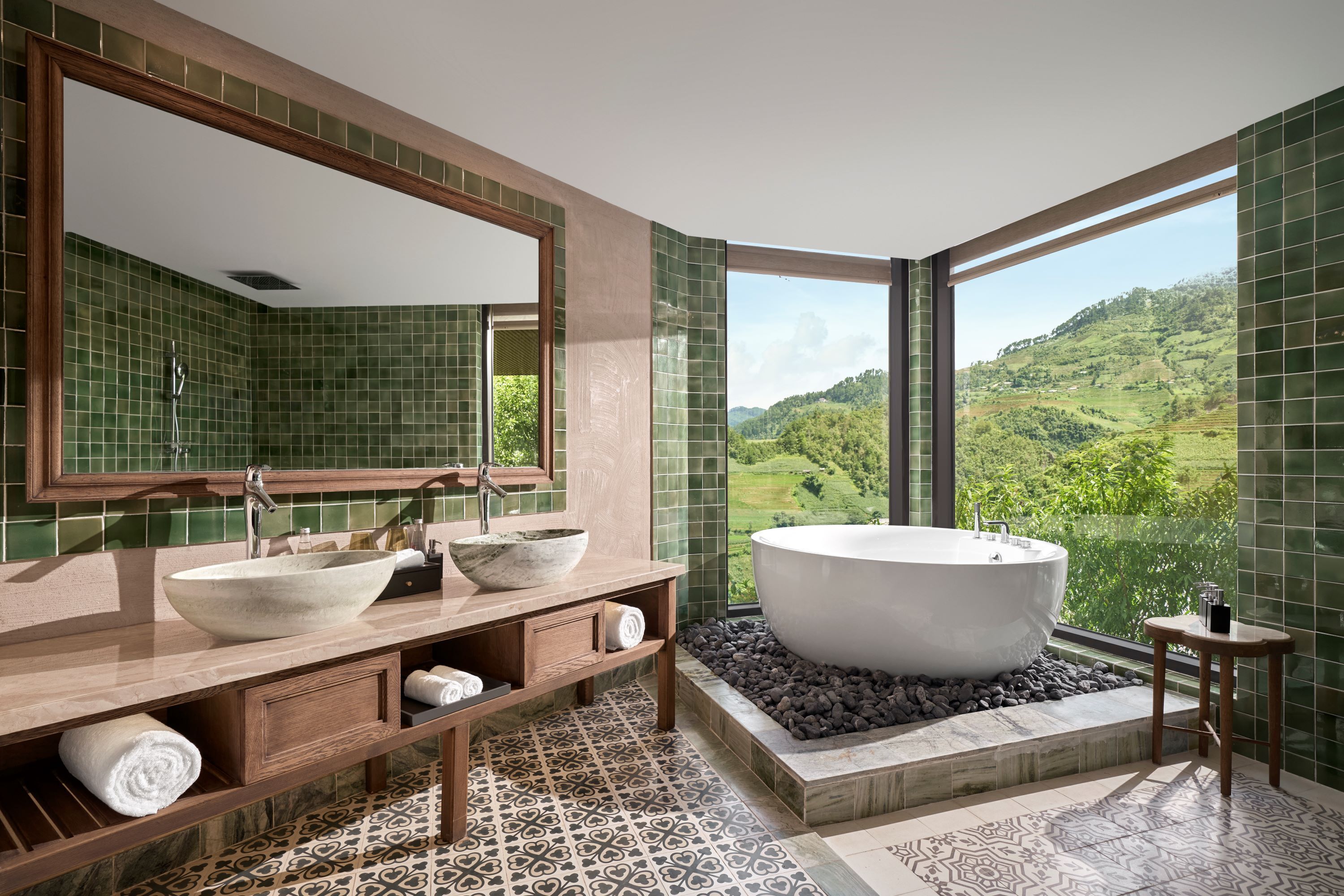 A modern bathroom with a large bathtub, a bowl sink, and a large mirror.