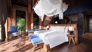 A bedroom with a bed, bedside tables, a chair, and a hanging canopy. - Garrya Mu Cang Chai (Mu Cang Chai)