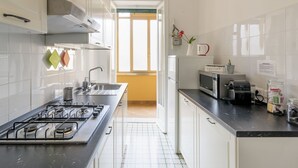 Eine moderne Küche mit Gasherd, Mikrowelle und Kaffeemaschine.