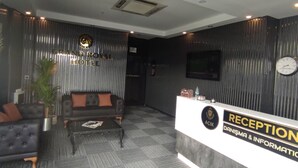 A modern reception area with a reception desk, a sofa, and a coffee table. - Grand Royal Hotel (Silivri)