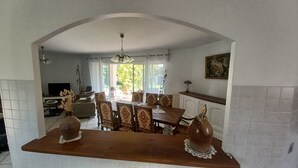 Un espace repas comprenant une table et des chaises, un téléviseur et une vue sur l’extérieur.
